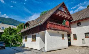 ein Haus mit einem Gamer-Dach und weißen Wänden in der Unterkunft Apartment Bernik II in Kranjska Gora