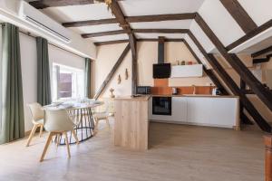 eine Küche und ein Esszimmer mit Tisch und Stühlen in der Unterkunft L’Alcôve Bourbonnaise - Au coeur de Montluçon in Montluçon