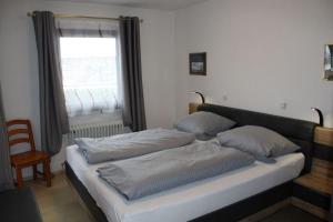 deux lits dans une chambre avec une fenêtre dans l'établissement Ferienhaus Nr 134, Kategorie Komfort, Feriendorf Hochbergle, Allgäu, à Lechbruck am See