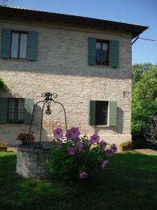 佩萨罗Romantico tramonto的一栋门前种着紫色花朵的房子