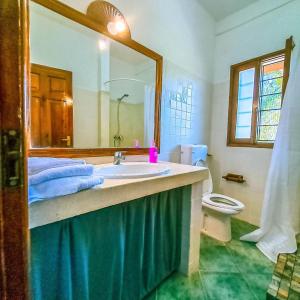 a bathroom with a sink and a toilet and a mirror at Modern Girasoli Suites 03 in Malindi