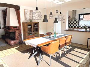 ein Esszimmer mit Tisch und Stühlen und einem Kamin in der Unterkunft Ferienhaus Wacholderhain in Haselünne