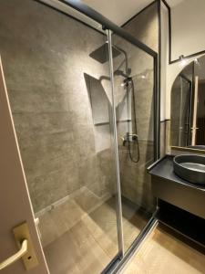 a bathroom with a glass shower and a sink at Appartement - Cambrai in Cambrai