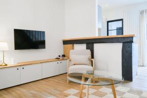 - un salon avec une table en verre et une chaise dans l'établissement Maison trois chambres avec cour, parking gratuit, à Croix