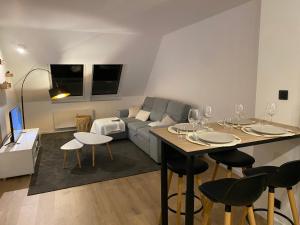 a living room with a couch and a table with wine glasses at Appartement - Cambrai in Cambrai