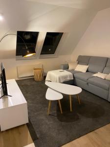 a living room with a couch and a table at Appartement - Cambrai in Cambrai