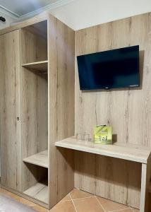 a living room with a tv on a wooden wall at Hotel Ibiza in Golem