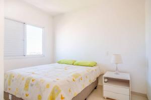 a white bedroom with a bed and a window at Apartamento encantador San Roman in Bauru +9 photos