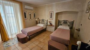 a room with two beds and a window at Vittoria Guest House Salerno in Salerno