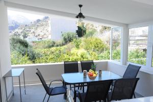 a dining room with a table and chairs and a large window at Hara's House in Tsoutsouros