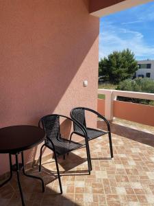 two chairs and a table on a patio at Apartman Tamaris in Vir