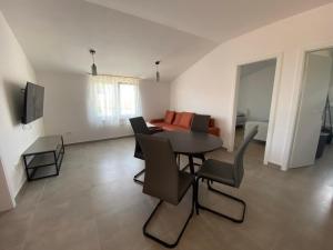 a living room with a table and chairs and a couch at Apartman Tamaris in Vir