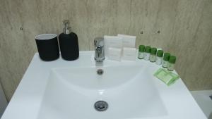 a white bathroom sink with bottles and a faucet at Stylish 4 Bd Ft LDN Parking in London