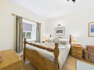 a bedroom with a wooden bed and a window at Tollymore Forest family house Mourne Mountains in Bryansford