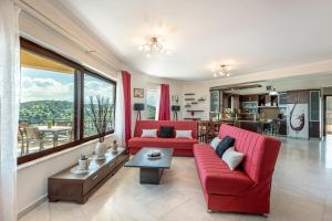 a living room with red furniture and a large window at Sunlit sea view apartments in Stalos
