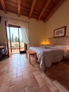 a bedroom with a bed and a table and a window at Casale Terre Rosse Garden in Saturnia