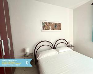 a bedroom with a white bed with white pillows at RS314 - Marcelli, bilocale in residence fronte mare in Marcelli