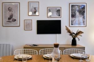 ein Esszimmer mit Tisch und Fernseher in der Unterkunft Maison 5 chambres & 5 sdb proche métro & commerces in Lille + 39 Fotos