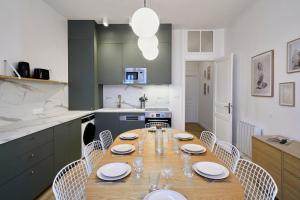 eine Küche mit einem Holztisch mit Stühlen und einem Esszimmer in der Unterkunft Maison 5 chambres & 5 sdb proche métro & commerces in Lille