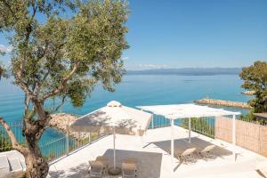 Una mesa y sillas con vista al agua. en Pouletis Family Apartments - Akroyali Seaview Getaways, en Kalamata