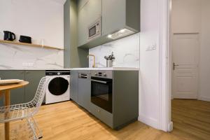 eine Küche mit einem Herd und einem Geschirrspüler in der Unterkunft Maison 5 chambres & 5 sdb proche métro & commerces in Lille