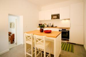 a kitchen with a wooden table and white cabinets at Casa da Serra - Entire 3 Bedroom House with Pool and Fireplace in Monchique