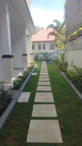 a walkway in front of a building with grass at Apartement Lucky Jimbaran in Jimbaran