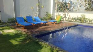 a swimming pool with chairs and a swimming pool at Apartement Lucky Jimbaran in Jimbaran