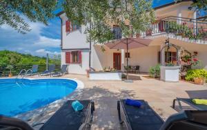 a villa with a swimming pool and a house at Klaudio Aqua Oaza Drenje in Drenje
