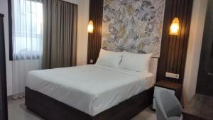 a bedroom with a large bed with white sheets at Apartement Lucky Jimbaran in Jimbaran +1 photo