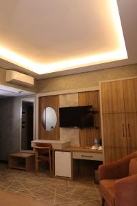 a living room with a desk and a tv on a wall at Mir Emir Hotel in Bostaniçi