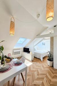 a white living room with a bed and a table at L'Eden - calme et luminosité au coeur de la ville in Fougères