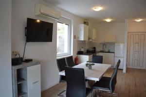 a kitchen and dining room with a table and a television at Apartma Korte in Izola