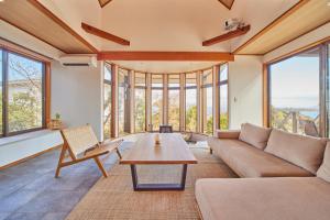 a living room with a couch and a table at プライベートリゾート熱川 in Higashiizu