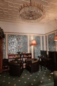 a living room with chairs and a chandelier at London Visitors Hotel in London +37 photos
