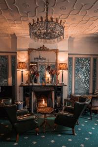 a living room with a fireplace and a chandelier at London Visitors Hotel in London