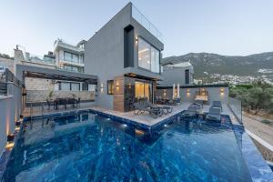 ein Haus mit einem Swimmingpool vor dem Haus in der Unterkunft Villa Cihan Kalkan in Kaş