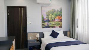 a bedroom with a bed and a painting on the wall at Royal Homestay And Coffee in Thôn Lại Thê