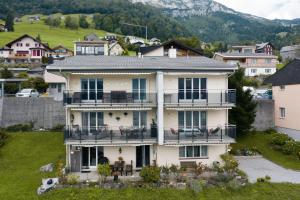 una grande casa bianca con balcone di Apartment Morgensonne ad Amden