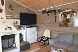 a living room with a couch and a painting of a cow at Flott hytte ved Bjellandsvegen in Vennesla