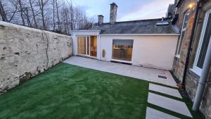 a backyard with a green lawn in front of a building at 5 Bedrooms Sleeps 10 Full Kitchen Parking in Ayr