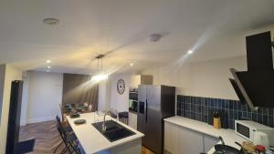 a kitchen with a black refrigerator and a counter top at 5 Bedrooms Sleeps 10 Full Kitchen Parking in Ayr +17 photos