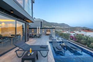 eine Außenterrasse mit Tischen und ein Pool auf einem Gebäude in der Unterkunft Villa Cihan Kalkan in Kaş