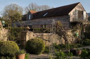 a house with a stone fence in front of it at The Long Barn at Brandiers in Minety