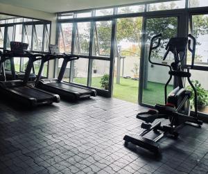 a gym with several treadmills and ellipticals in a room at Serenity Staycation Studio in Iloilo City
