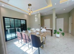 a large dining room with a table and chairs at Jmpoolvilla in Nakhon Si Thammarat