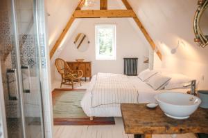 a bathroom with two beds and a sink in a room at Magnifique maison pour 8 avec jardin in Guissény
