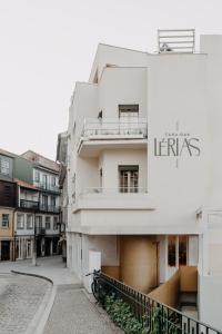 a white building with a sign on the side of it at Casa das Lérias in Amarante