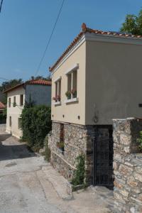 a house with a gate and a stone wall at Calypso 2 Rural Experience at the heart of Makri in Mákri