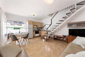 a living room with a staircase and a kitchen at Home2Book Cozy Dúplex & Spacious Terrace in Órzola in Orzola